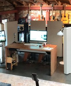 GIK Acoustics Freestand Akustikwand in large brick-wall studio with desk and computer screen